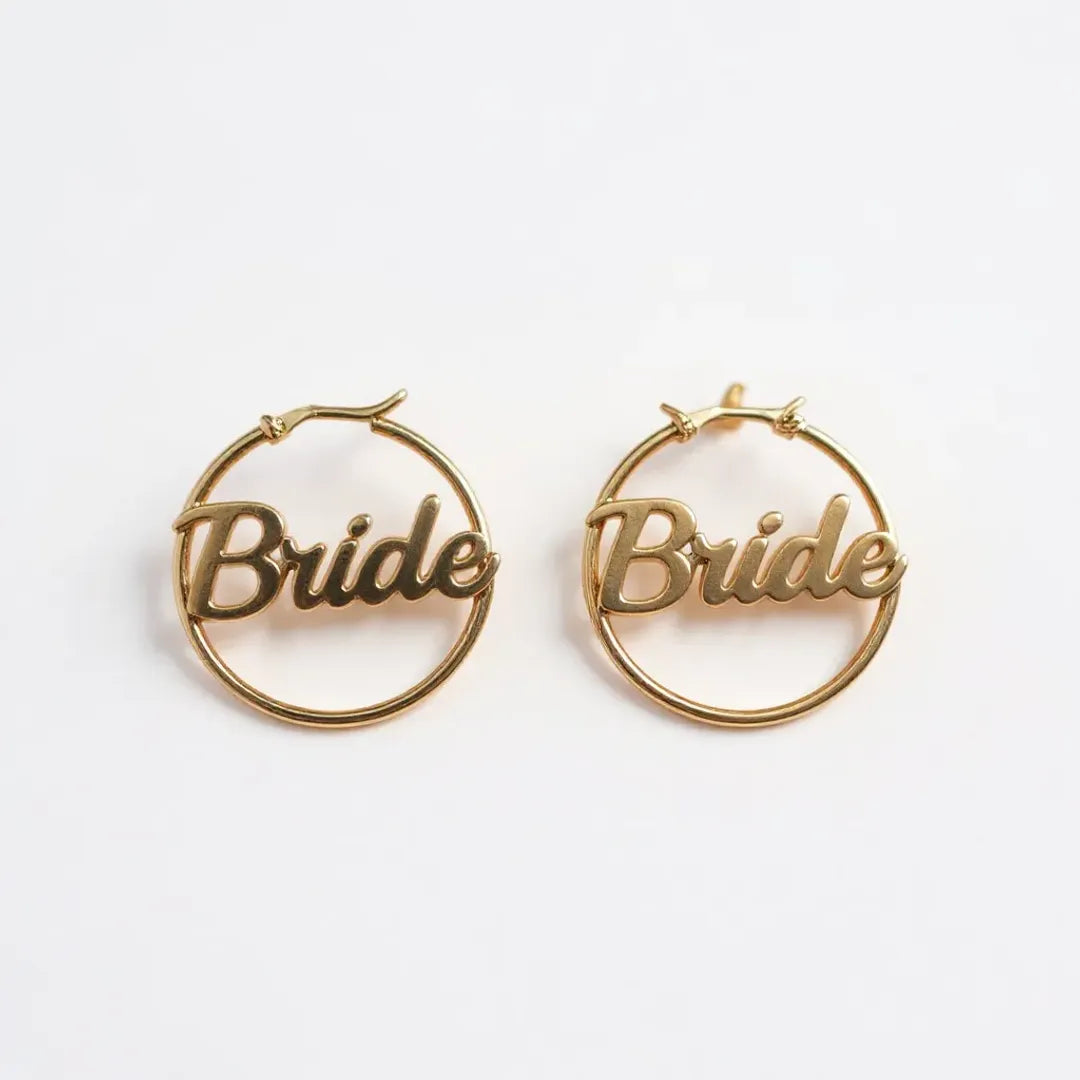 Gold hoop earrings with 'Bride' inscription on a white background